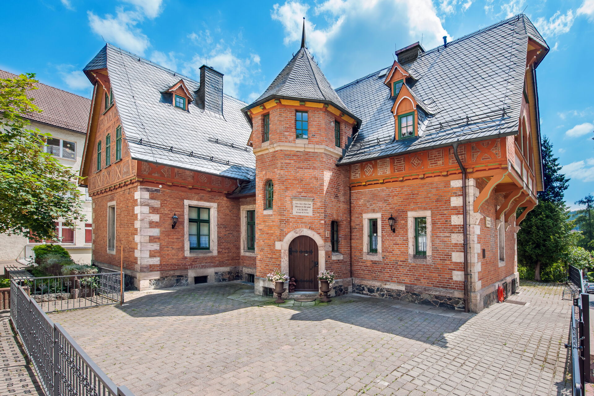 Die imposante Fassade der Seniorenresidenz Preller-Villa in Ilmenau, ein historisches Backsteingebäude mit Turm und Schieferdach.