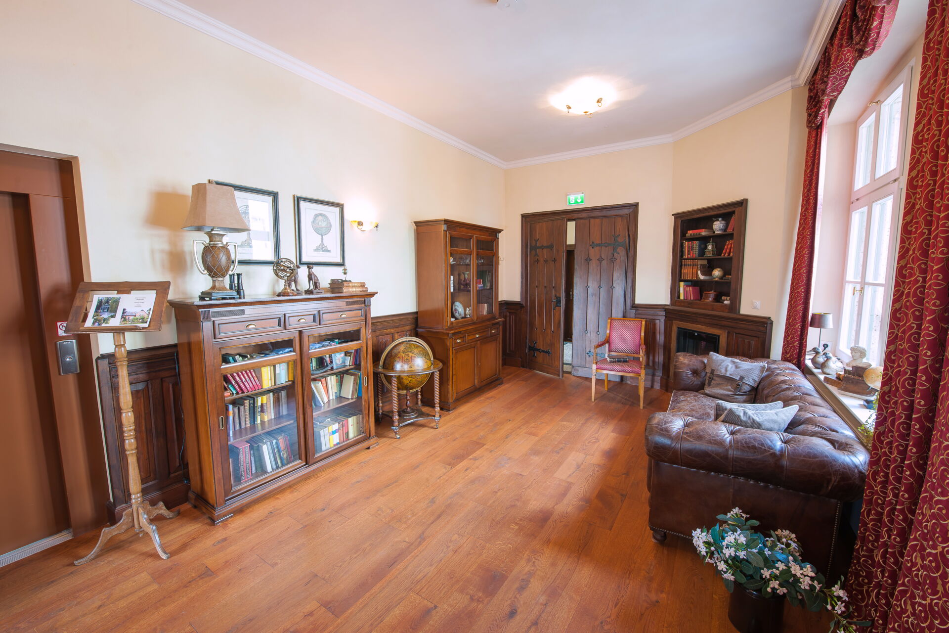 Ein stilvolles Wohnzimmer in einer Villa mit Holzboden und cremefarbenen Wänden.